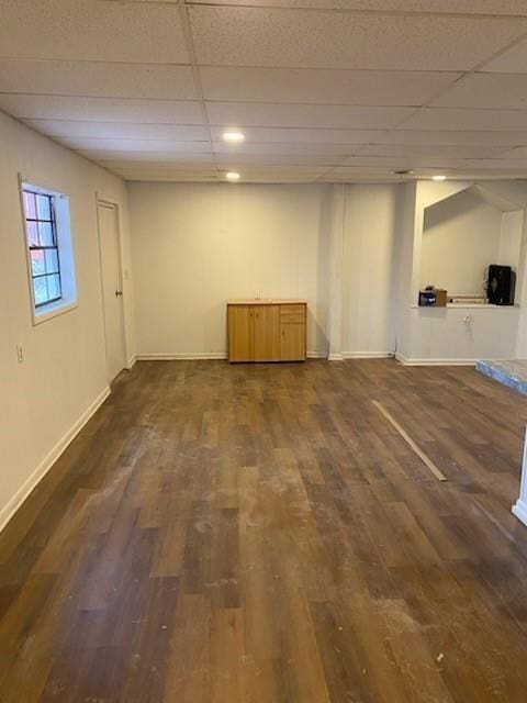 basement with a paneled ceiling and dark hardwood / wood-style flooring