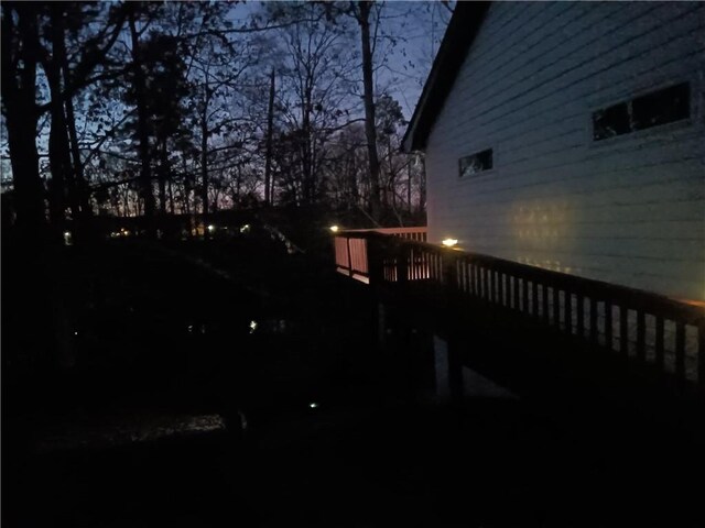 yard at dusk featuring a wooden deck