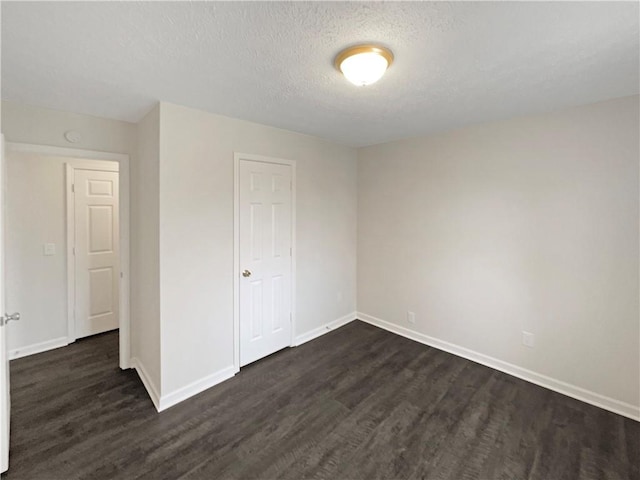 unfurnished room with dark hardwood / wood-style floors and a textured ceiling