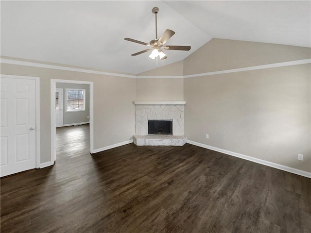 unfurnished living room featuring a stone fireplace, vaulted ceiling, dark hardwood / wood-style floors, and ceiling fan