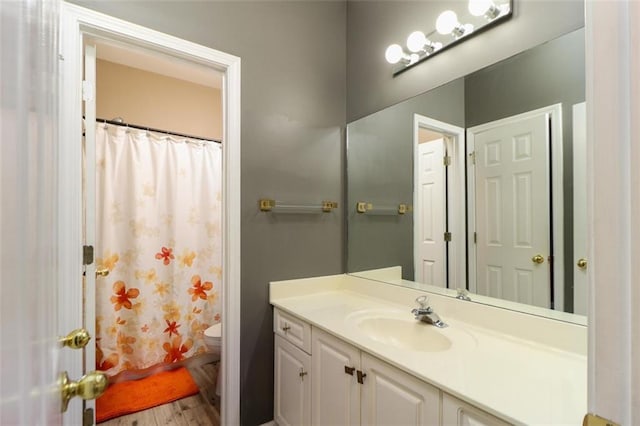 bathroom featuring wood finished floors, vanity, toilet, and a shower with curtain