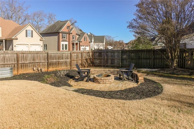 view of yard featuring a fire pit, a fenced backyard, and a residential view