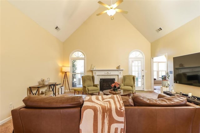 carpeted living room with a fireplace, visible vents, and a wealth of natural light