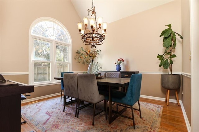 dining area with lofted ceiling, a healthy amount of sunlight, baseboards, and wood finished floors