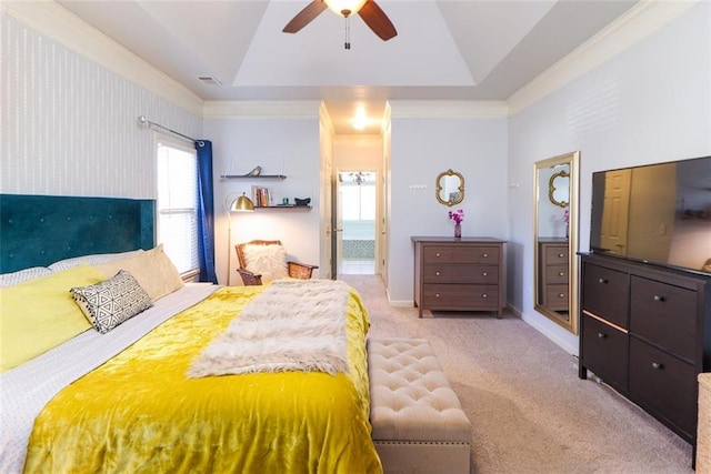 bedroom with carpet floors, visible vents, baseboards, a raised ceiling, and crown molding