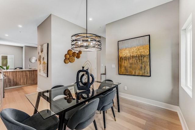 dining area with light hardwood / wood-style flooring and a chandelier