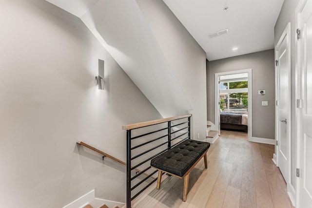 hallway featuring light wood-type flooring and lofted ceiling