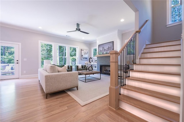 living room with a fireplace, recessed lighting, light wood-style flooring, stairway, and ceiling fan