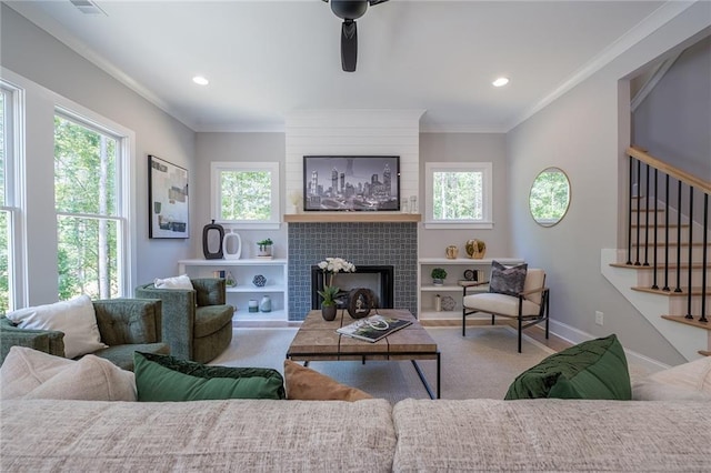 living area featuring plenty of natural light, stairway, and crown molding