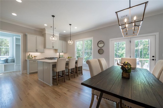 dining space featuring ornamental molding, a wealth of natural light, and light wood-style floors