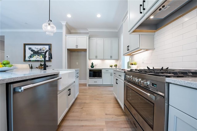 kitchen featuring hanging light fixtures, light stone countertops, white cabinetry, and appliances with stainless steel finishes