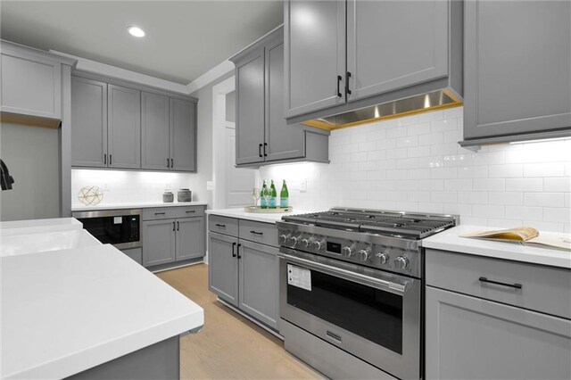 details featuring light stone counters, high end stainless steel range, and tasteful backsplash