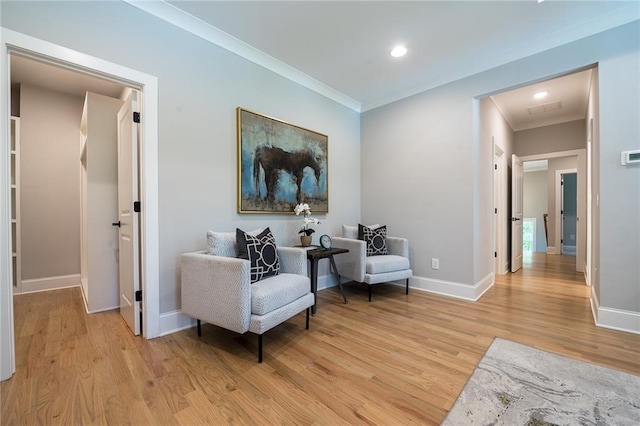 living area featuring ornamental molding, recessed lighting, light wood-style flooring, and baseboards