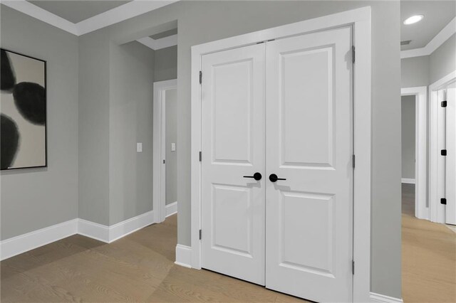 bedroom featuring baseboards, light wood-style flooring, a tray ceiling, crown molding, and recessed lighting