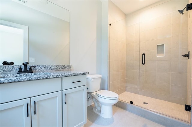 bathroom featuring toilet, tile patterned flooring, a shower stall, and vanity