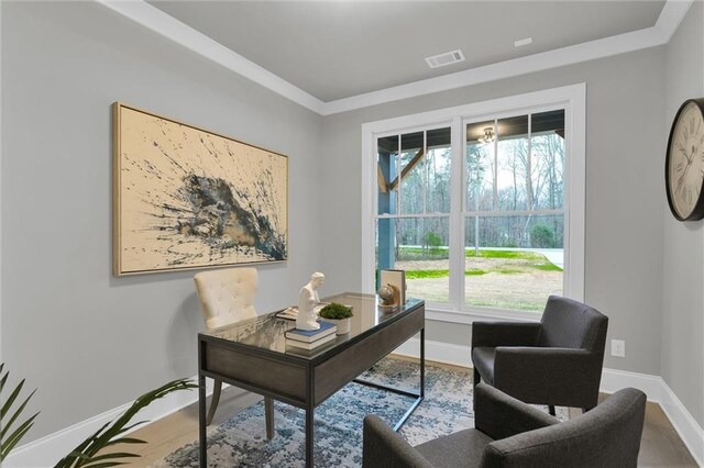 home office with ornamental molding, light wood-style floors, and an inviting chandelier