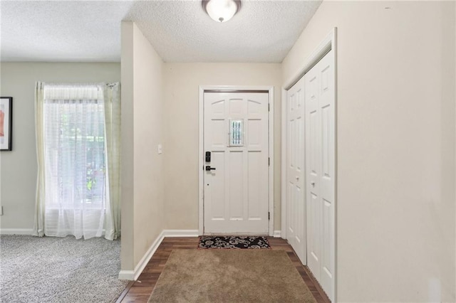 entrance foyer with a textured ceiling and dark hardwood / wood-style floors