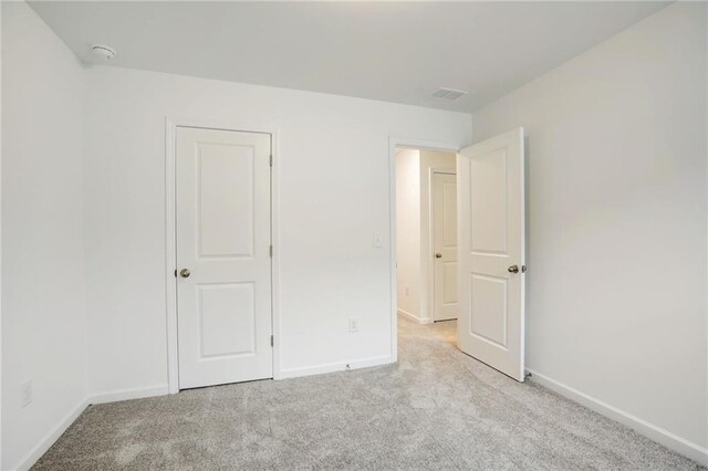 unfurnished bedroom with light colored carpet