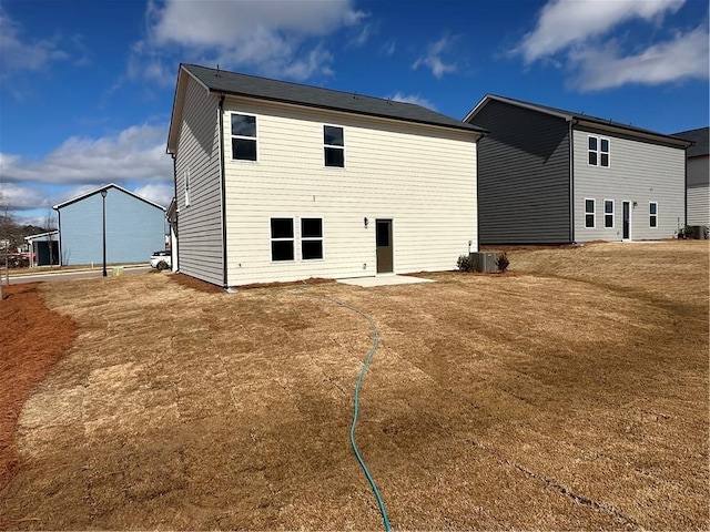 back of property with a yard and central air condition unit