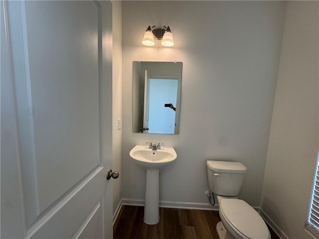 bathroom with hardwood / wood-style flooring, sink, and toilet