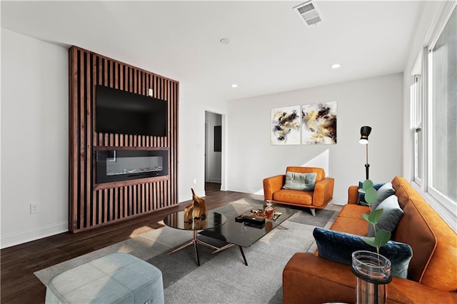 living area featuring recessed lighting, visible vents, baseboards, and wood finished floors