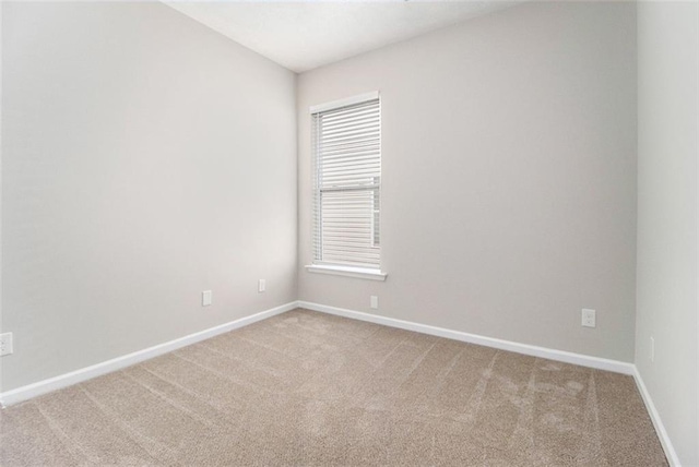 carpeted empty room with baseboards