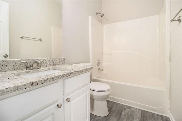 full bath featuring vanity, tub / shower combination, wood finished floors, and toilet