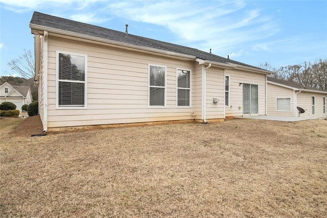 rear view of house featuring a yard and a patio