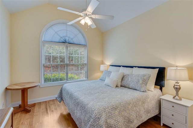 bedroom with ceiling fan, baseboards, lofted ceiling, and wood finished floors