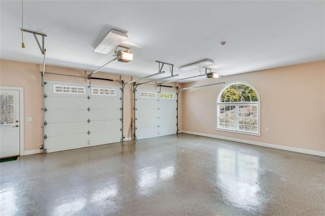 garage featuring a garage door opener and baseboards