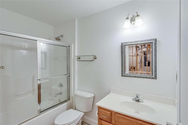 full bathroom with enclosed tub / shower combo, toilet, and vanity