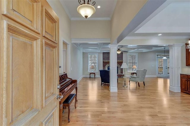 foyer featuring decorative columns, light wood-style floors, baseboards, and ceiling fan