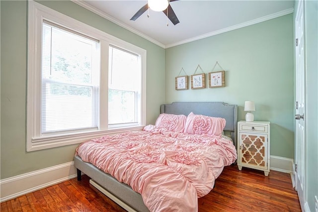 bedroom featuring a ceiling fan, crown molding, baseboards, and wood finished floors