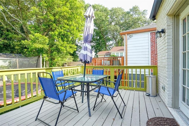 deck with a trampoline and outdoor dining area