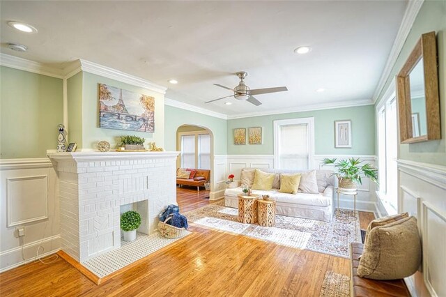 interior space with ceiling fan, a brick fireplace, and arched walkways