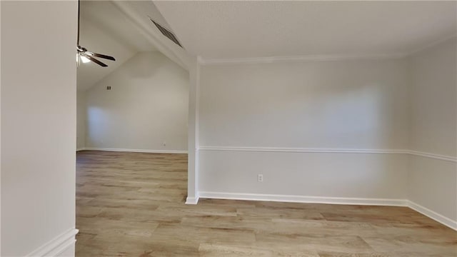 spare room featuring light hardwood / wood-style flooring, ceiling fan, and vaulted ceiling