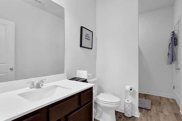 bathroom featuring toilet, vanity, and hardwood / wood-style flooring