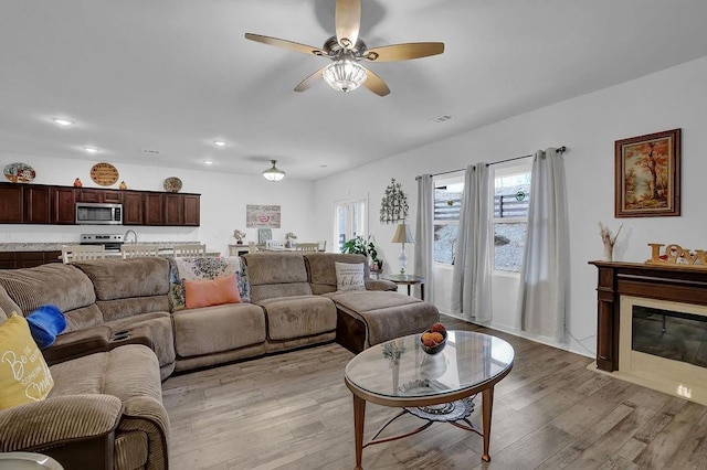 living room with light wood-type flooring and ceiling fan