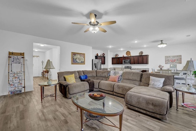 living room featuring ceiling fan and light hardwood / wood-style floors