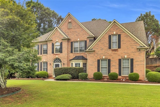 947 Summer Forest Dr, Suwanee, GA 30024 - view of front of home with brick siding, a front lawn, and roof with shingles