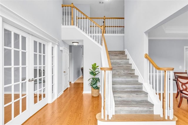 947 Summer Forest Dr, Suwanee, GA 30024 - staircase featuring wood finished floors, crown molding, french doors, a towering ceiling, and baseboards