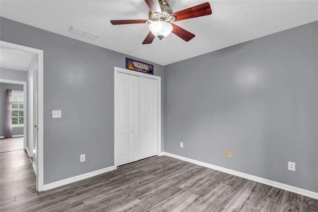 947 Summer Forest Dr, Suwanee, GA 30024 - unfurnished bedroom with wood finished floors, baseboards, a closet, and a ceiling fan