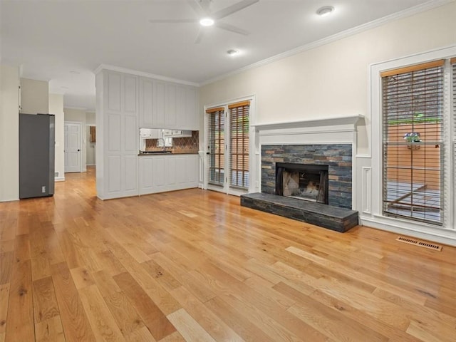 4515 N Slope Cir, Marietta, GA 30066 - unfurnished living room featuring light wood-type flooring, ornamental molding, ceiling fan, and a stone fireplace