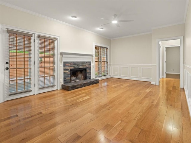 4515 N Slope Cir, Marietta, GA 30066 - unfurnished living room featuring a wainscoted wall, a fireplace, light wood-type flooring, a ceiling fan, and crown molding