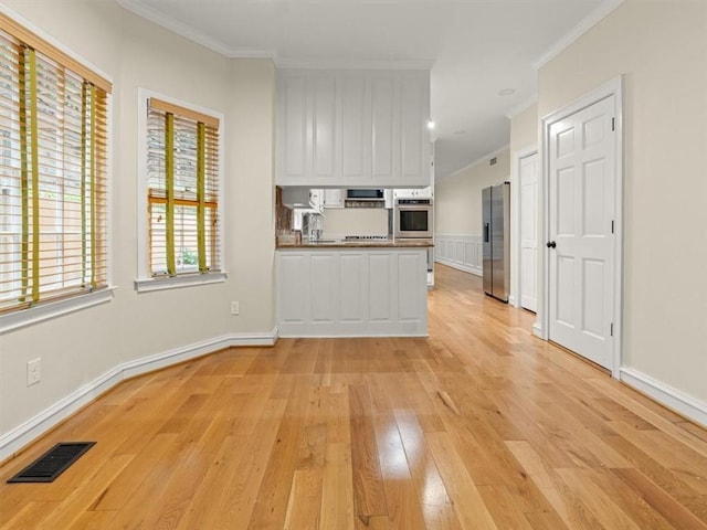 4515 N Slope Cir, Marietta, GA 30066 - kitchen with crown molding, light wood-style flooring, visible vents, and appliances with stainless steel finishes