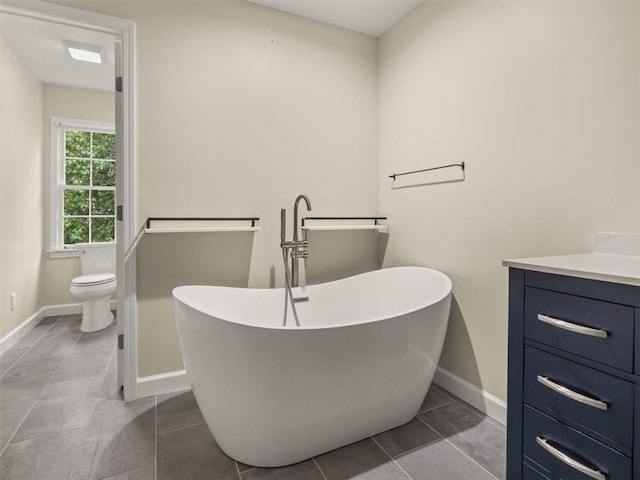 4515 N Slope Cir, Marietta, GA 30066 - bathroom featuring vanity, tile patterned floors, toilet, a freestanding bath, and baseboards