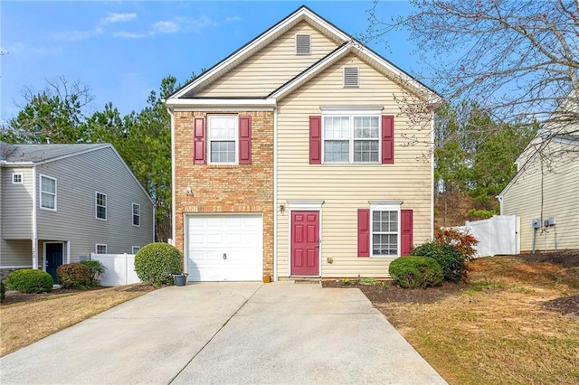 traditional-style house with brick siding, driveway, an attached garage, and fence