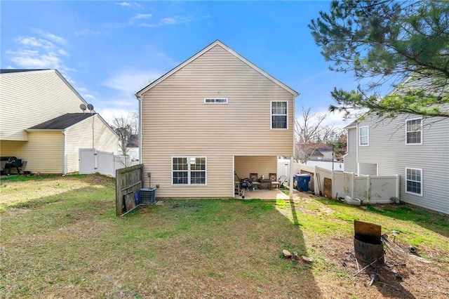 rear view of property featuring cooling unit, a patio area, a lawn, and fence