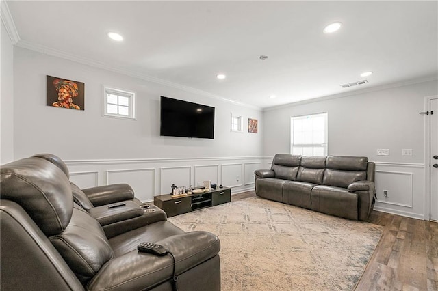 living room with ornamental molding, wood finished floors, and a wealth of natural light