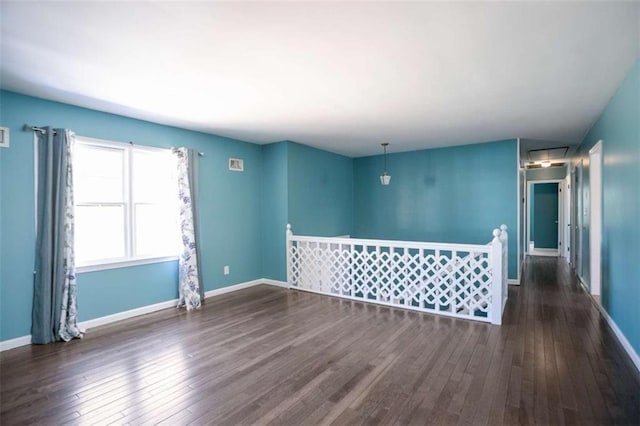 unfurnished room with baseboards and wood finished floors